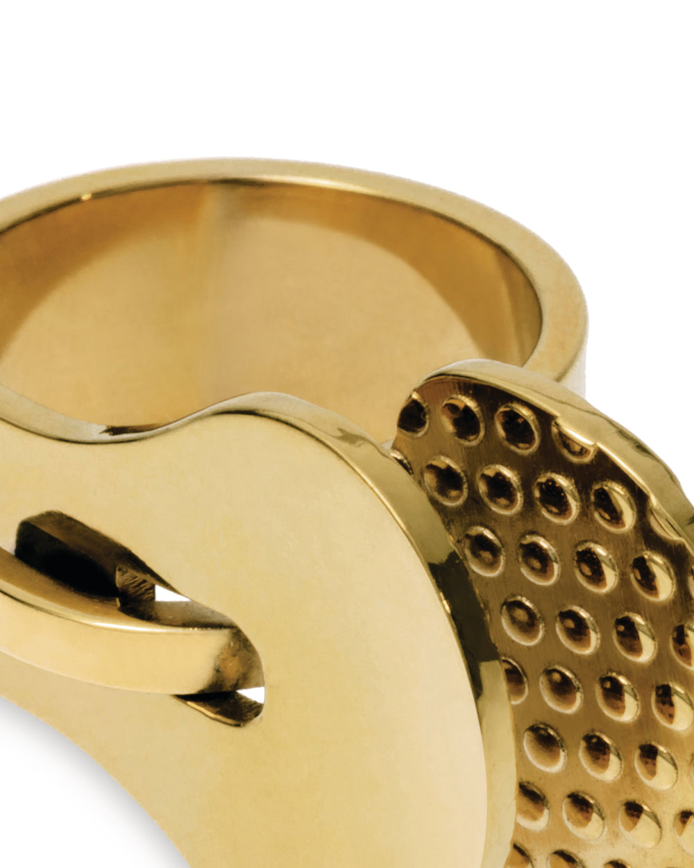 Gold-toned metal object by Alessi, detailed with a grid of small concave indentations in a close-up.