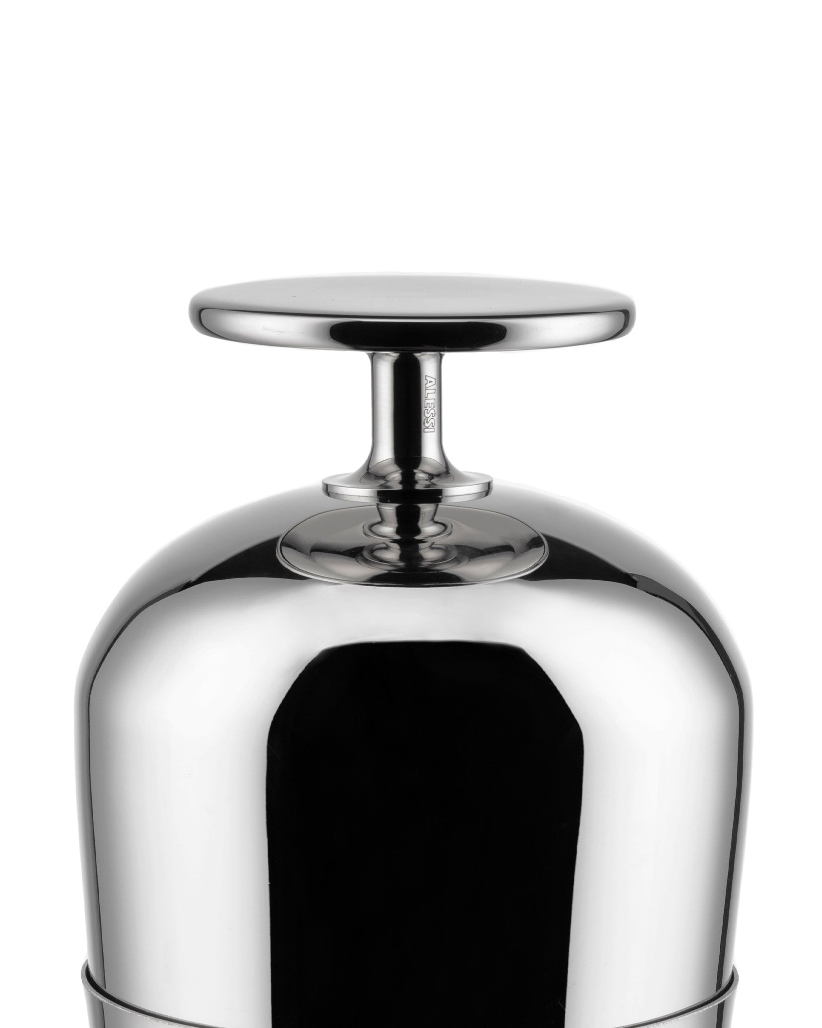 Polished metal Tending Box lid by Alessi with a flat circular handle and engraved logo on the stem.