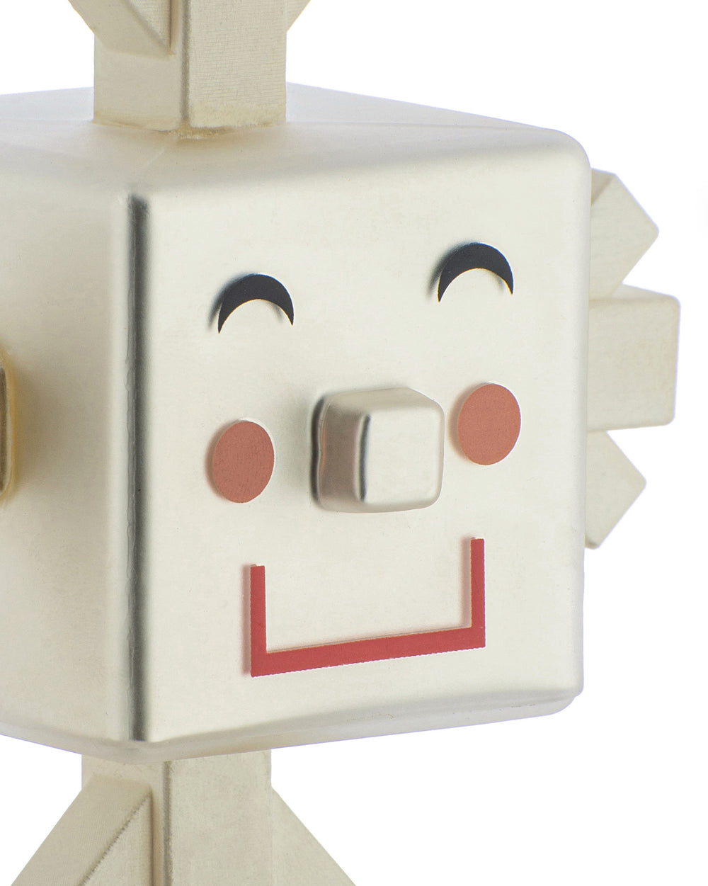Creamy white geometric character figurine by Alessi with a smiling face, metallic nose, and red mouth.