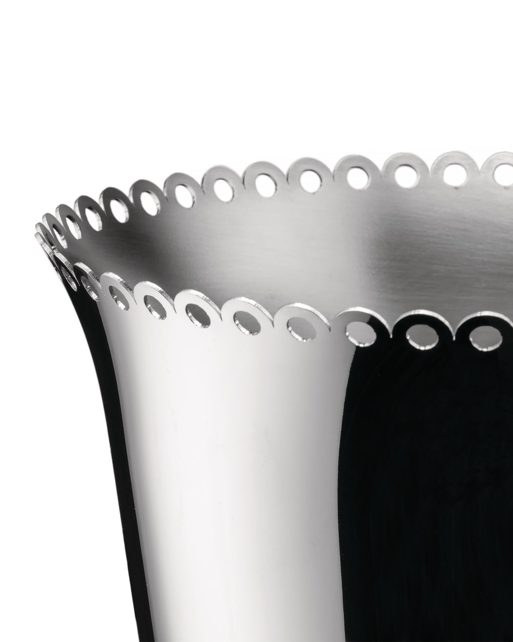 Silver metal wine cooler by Alessi with a scalloped, perforated rim in a close-up, angled view.
