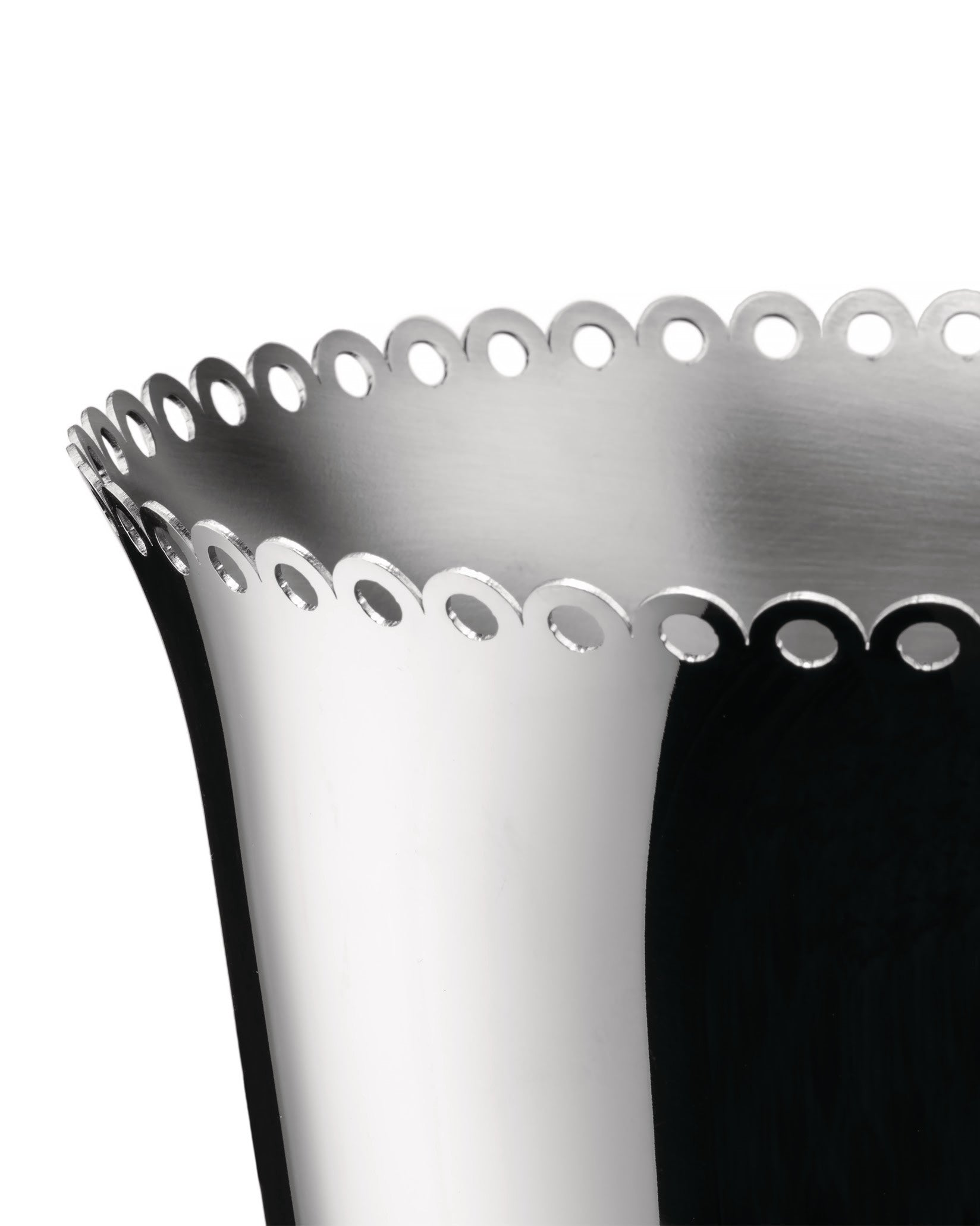 Silver metal wine cooler by Alessi with a scalloped, perforated rim in a close-up, angled view.