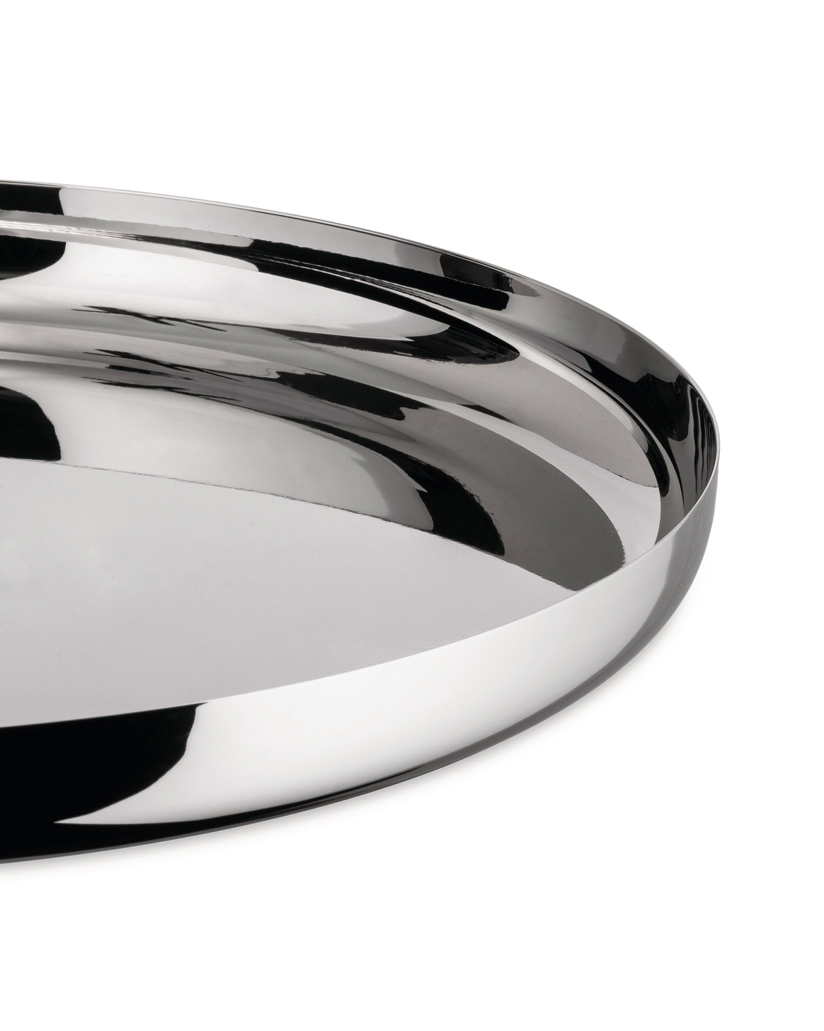 Polished chrome serving tray by Alessi, with a highly reflective surface and smooth, curved edges, partial view.