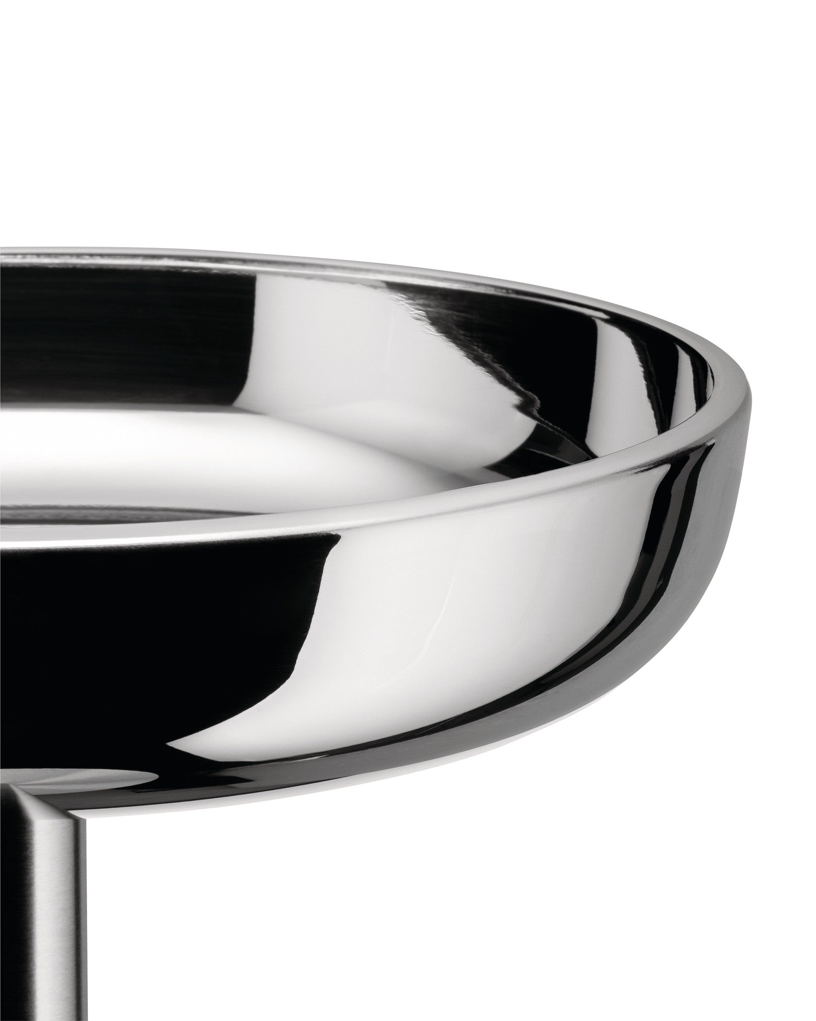 Polished stainless steel bowl by Alessi with a highly reflective, curved interior and exterior, cropped.