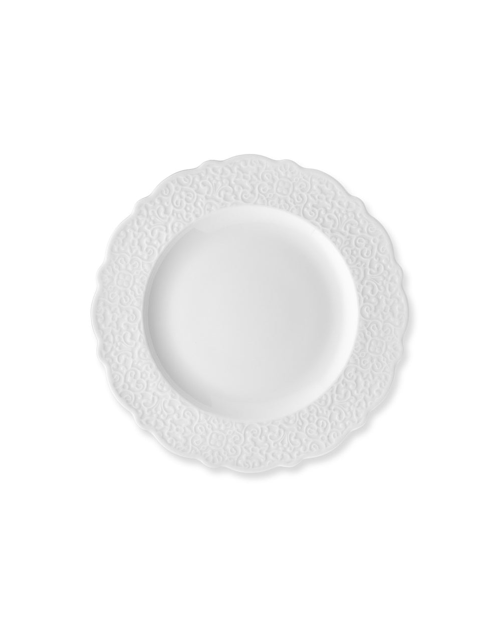 White plate by Alessi with a scalloped edge and embossed scroll pattern.