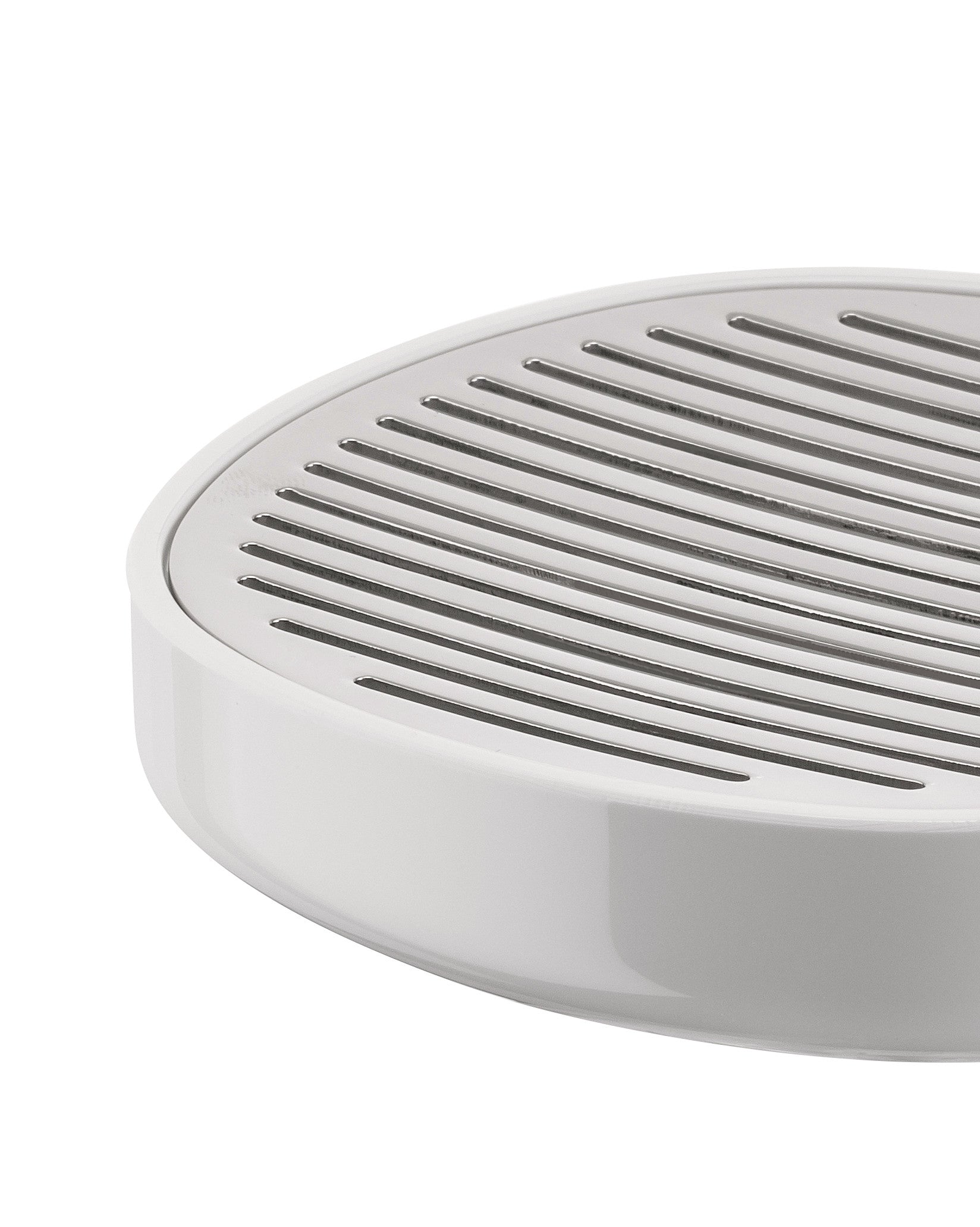 White slotted soap dish by Alessi with a metallic draining top, in a close-up angled view.