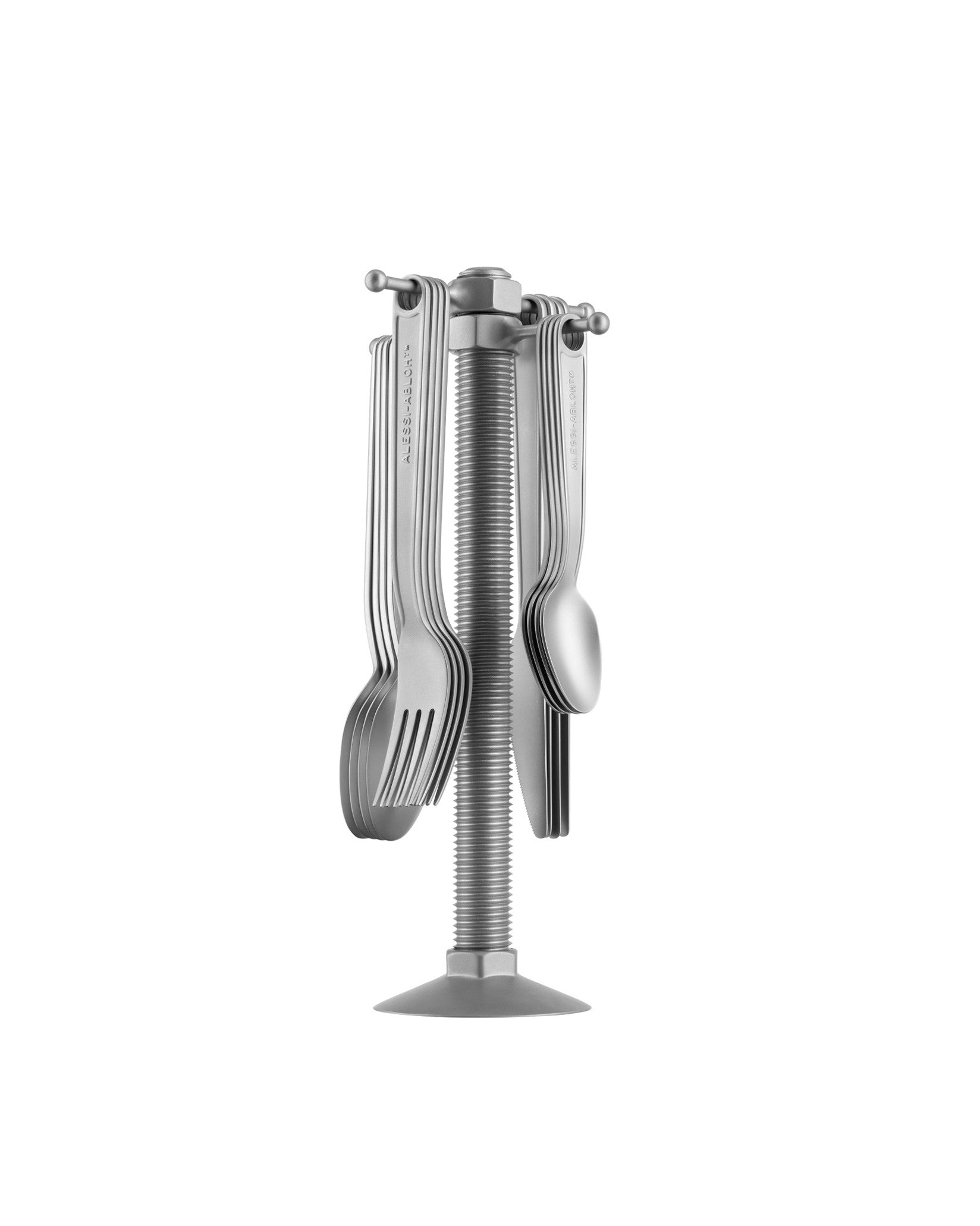 Silver-toned metal cutlery set by Alessi displayed on a threaded bolt stand with engraved handles.