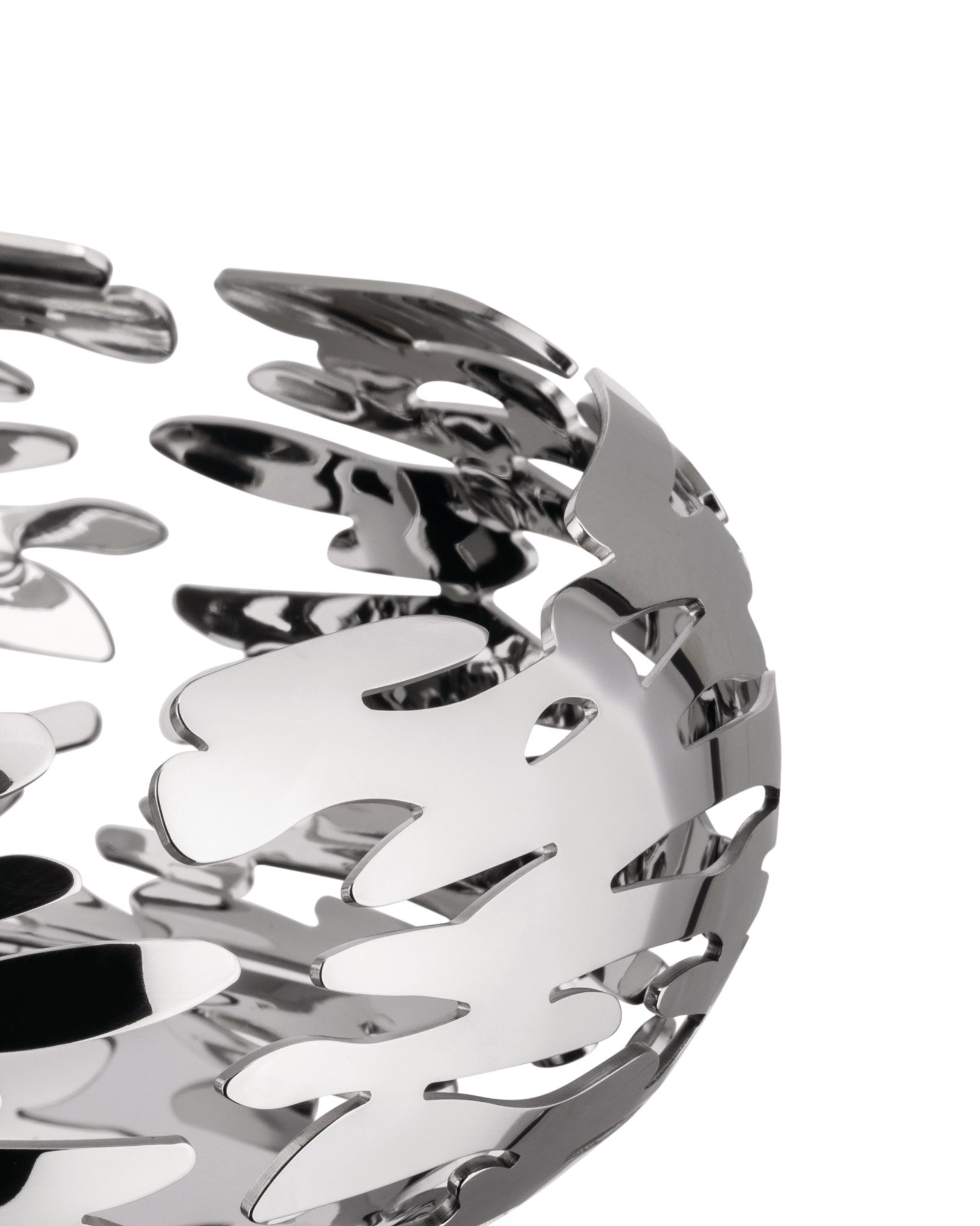 Silver-toned metallic bowl by Alessi with an intricate, flame-like cut-out pattern, cropped view.