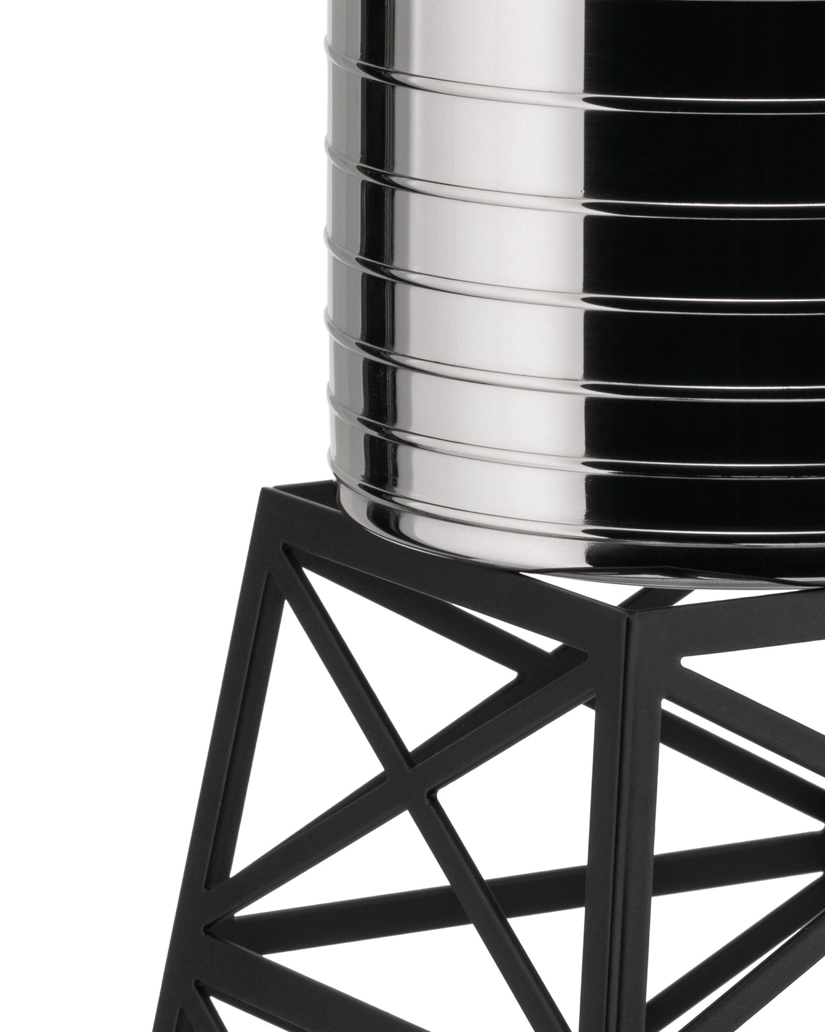 Silver polished Water Tower by Alessi with grooved cylinder on a black geometric stand, close-up.