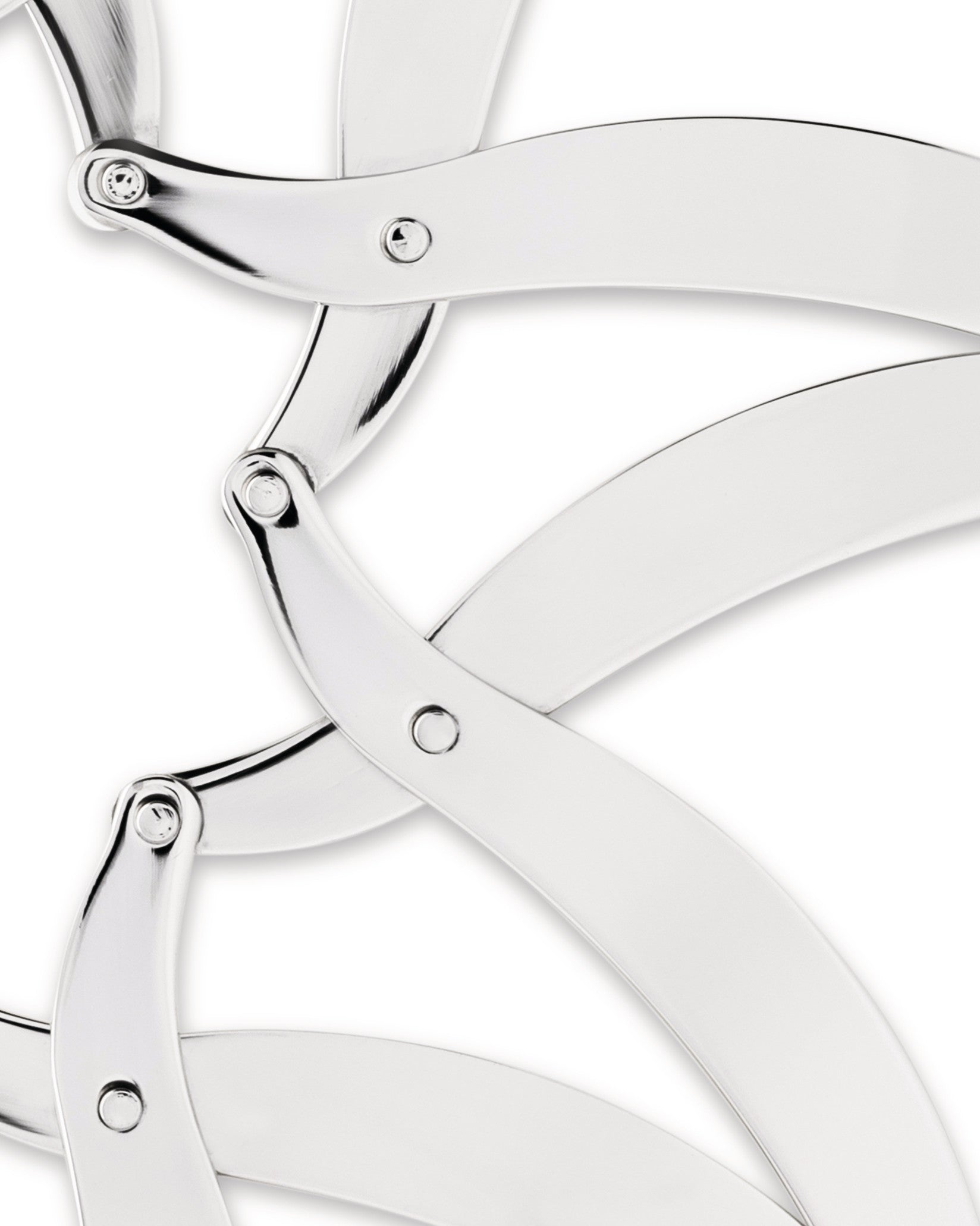 Silver metal trivet by Alessi, featuring interlocking curved arms with a shiny, reflective surface, cropped close-up.