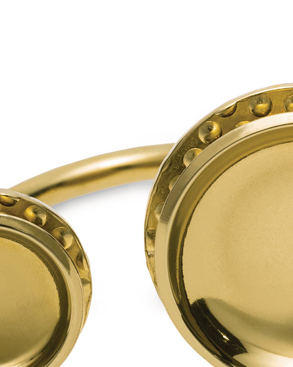 Golden metal multi-bowl by Alessi, featuring shiny circular dishes and an embossed dotted rim.