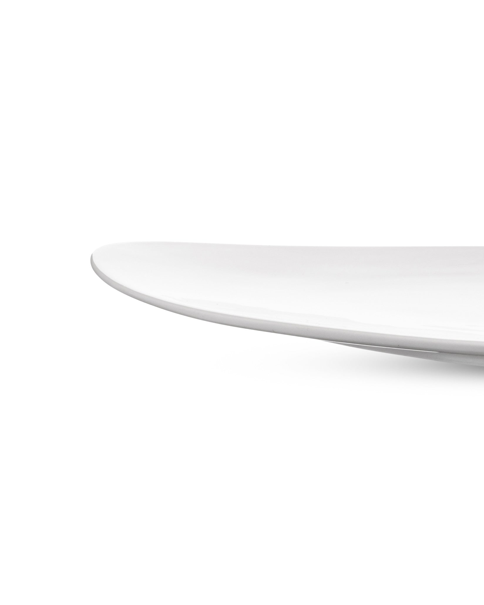 White serving plate by Alessi with a smooth, curved edge.