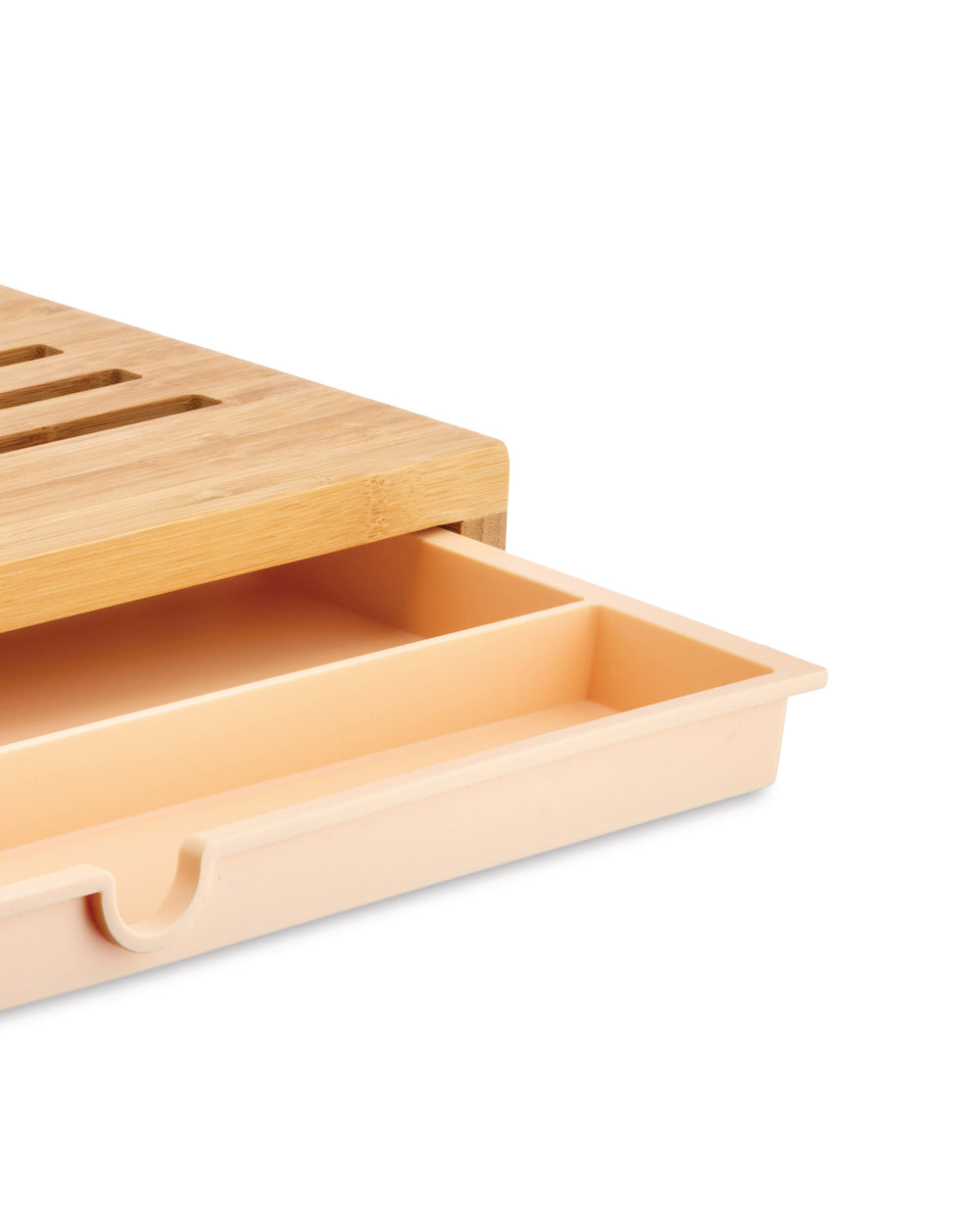 Bamboo chopping board by Alessi with slats and a light peach pull-out drawer featuring two compartments and a U-shaped handle.