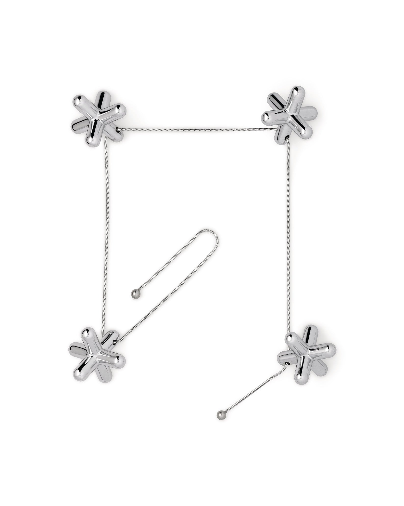 Silver metallic tripod trivet by Alessi, with four jack-shaped pieces linked by thin chains forming a square, plus an extra chain.
