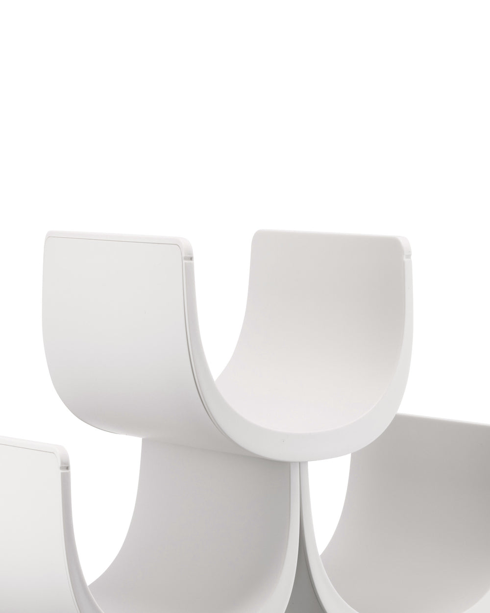 White modular wine rack by Alessi, featuring curved, interlocking sections in a close-up view.