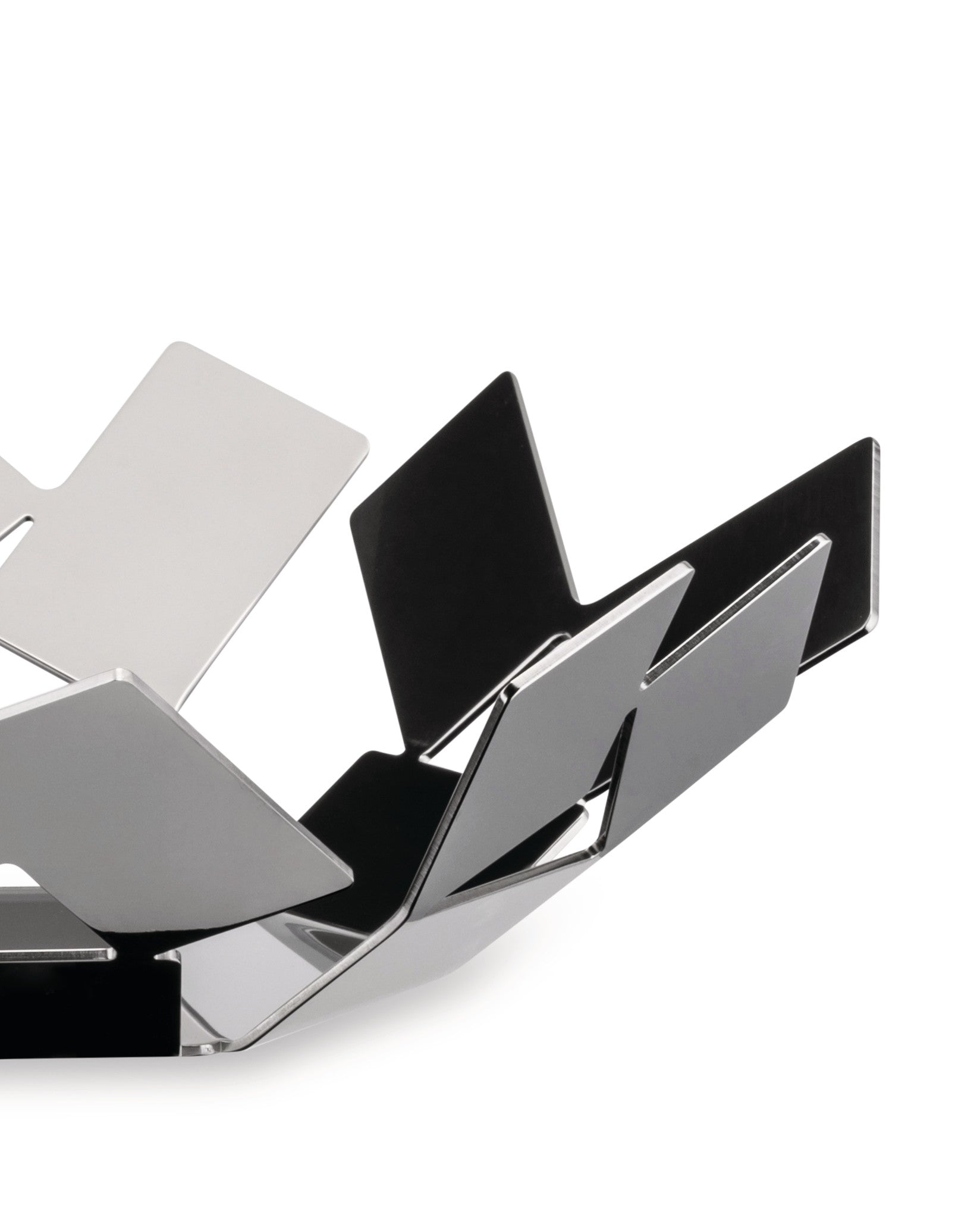 Polished metal decorative bowl by Alessi, featuring a sculptural geometric folded design with reflective surfaces.