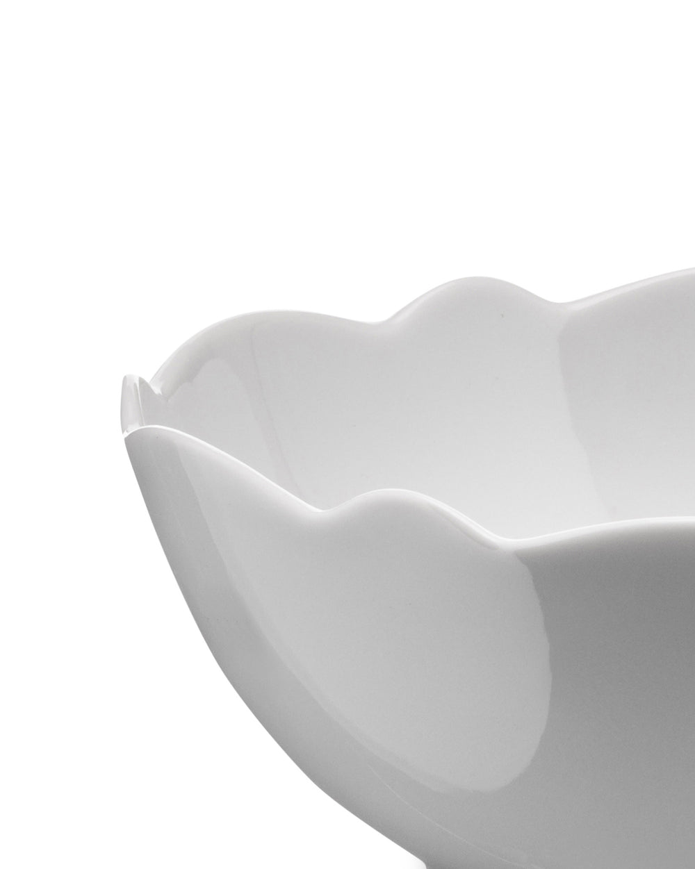 White serving bowl by Alessi with an elegant wavy rim, angled view.