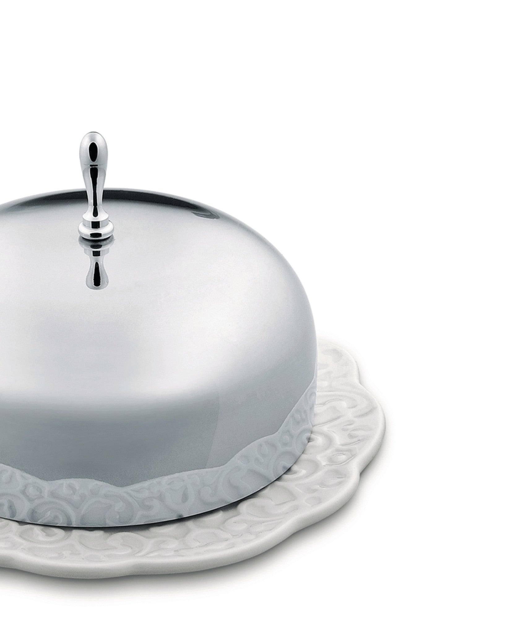 Silver metal cloche with handle and white ceramic plate by Alessi, featuring ornate embossed designs on both pieces.