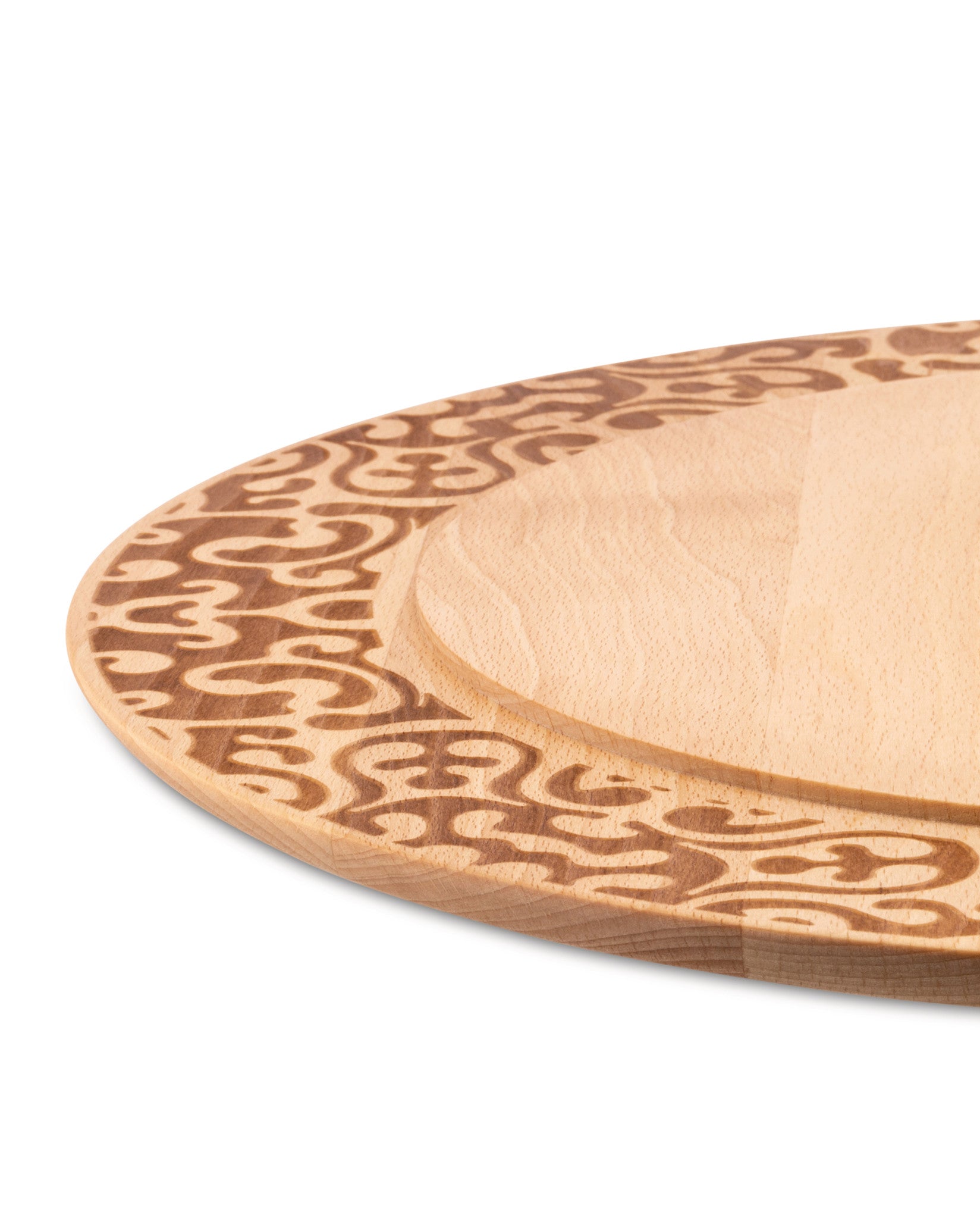 Wooden chopping board by Alessi, featuring an engraved swirly pattern around a recessed central area, in an angled close-up.