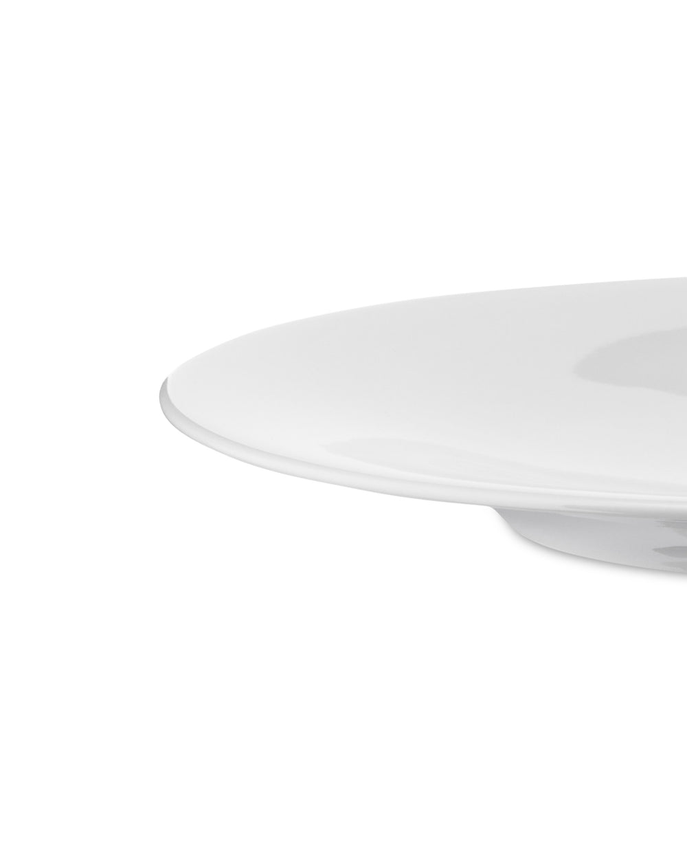 White plate by Alessi with a smooth, glossy surface, captured from a low, cropped side angle.