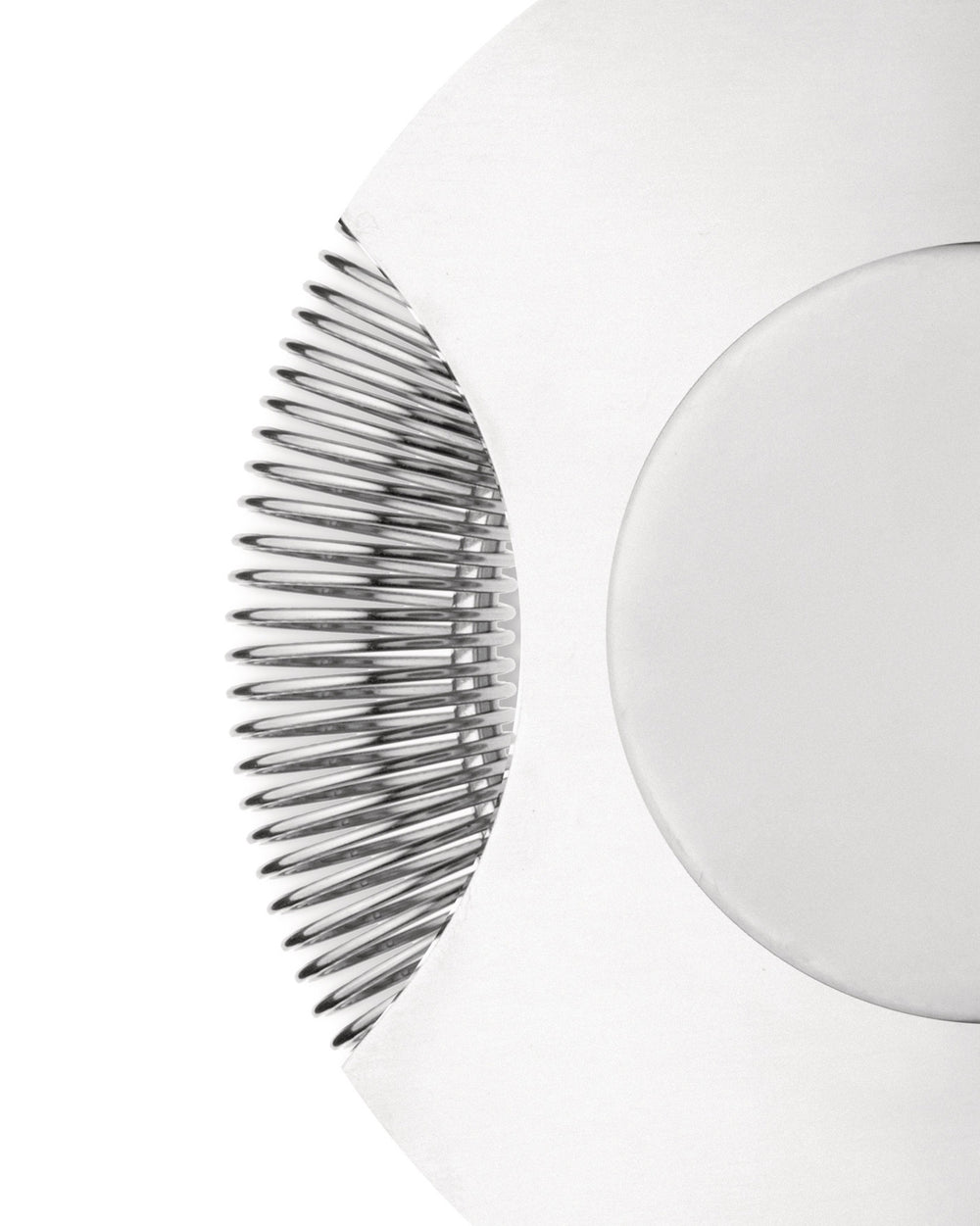 The tending box with silver metallic ribs and a smooth white curve by Alessi, in a cropped, abstract close-up.