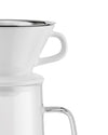 White ceramic and clear glass slow coffee maker by Alessi, with a stainless steel rim and handles, cropped.
