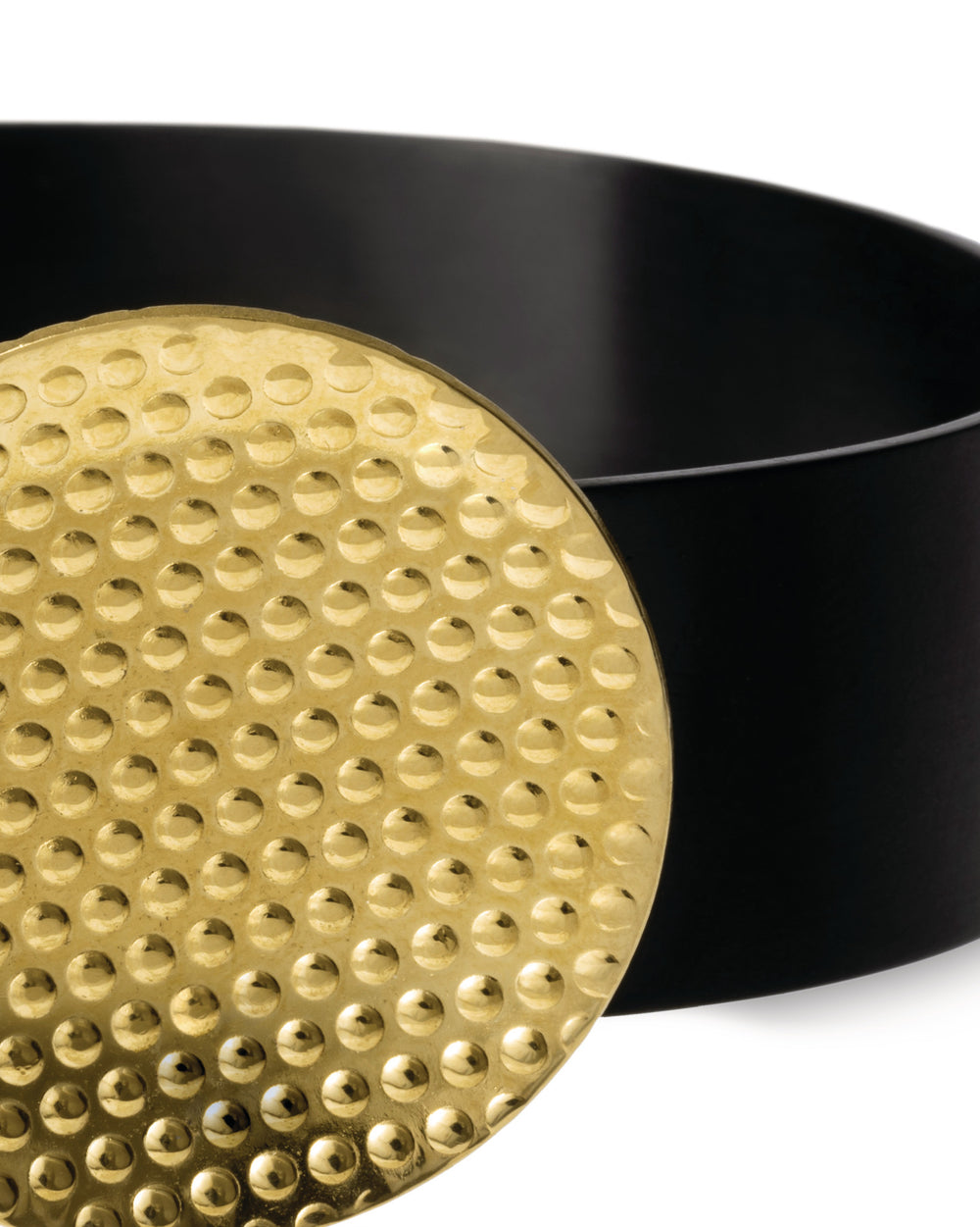 Gold dimpled disc by Alessi, partially covering a curved matte black container.