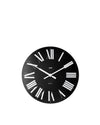 Black round wall clock by Alessi, featuring white Roman numerals, white hands, and visible Alessi branding.