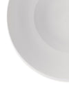 White ceramic dish by Alessi, with a smooth, reflective surface and gently curved rim.
