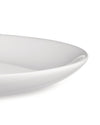 A white, glossy serving dish by Alessi with gently curved edges, shown in a close-up, cropped view.