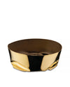 Golden metallic bowl by Alessi with a compressed shape, featuring a shiny exterior and dark interior.