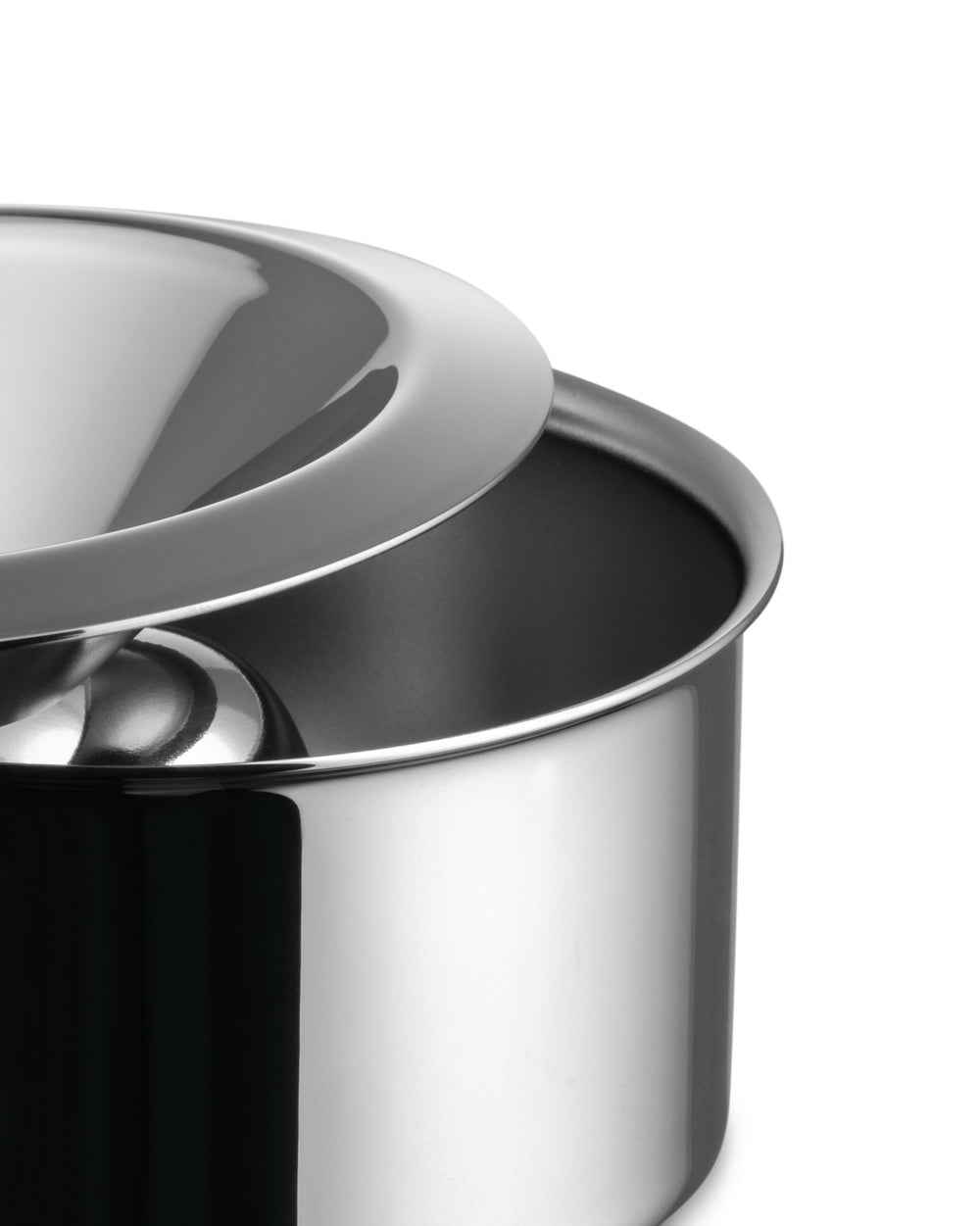 Polished stainless steel serving bowl by Alessi with a sleek, domed lid, in a close-up view.
