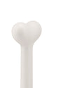 Matte white heart-shaped object by Alessi, featuring a smooth finish and thick cylindrical base, shown cropped.