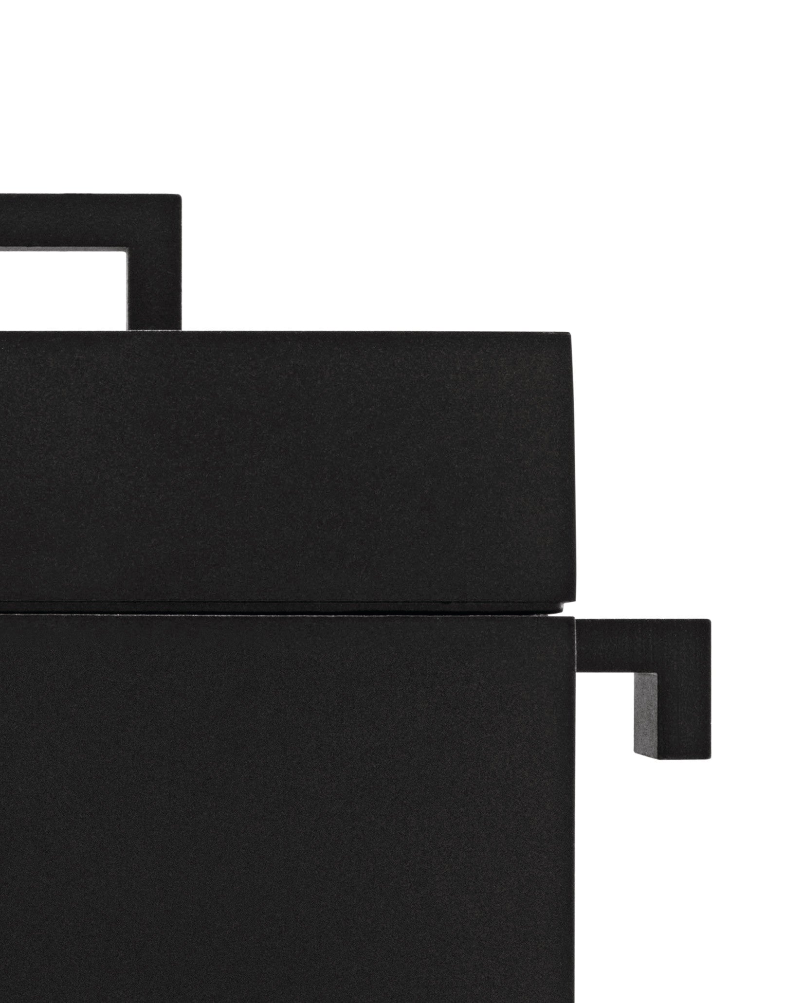 Black textured cubic product by Alessi featuring sharp, angular components, shown cropped.