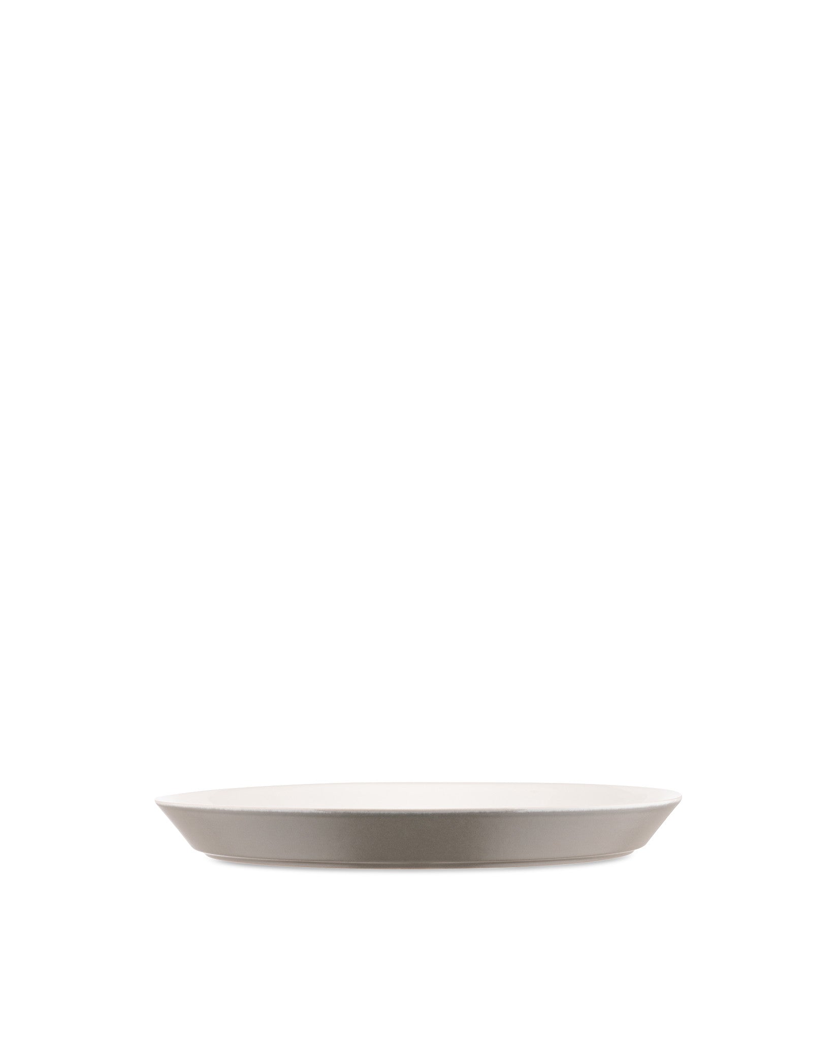 A Tonale ceramic plate by Alessi, with a white interior and a light taupe exterior, shown in a side view.