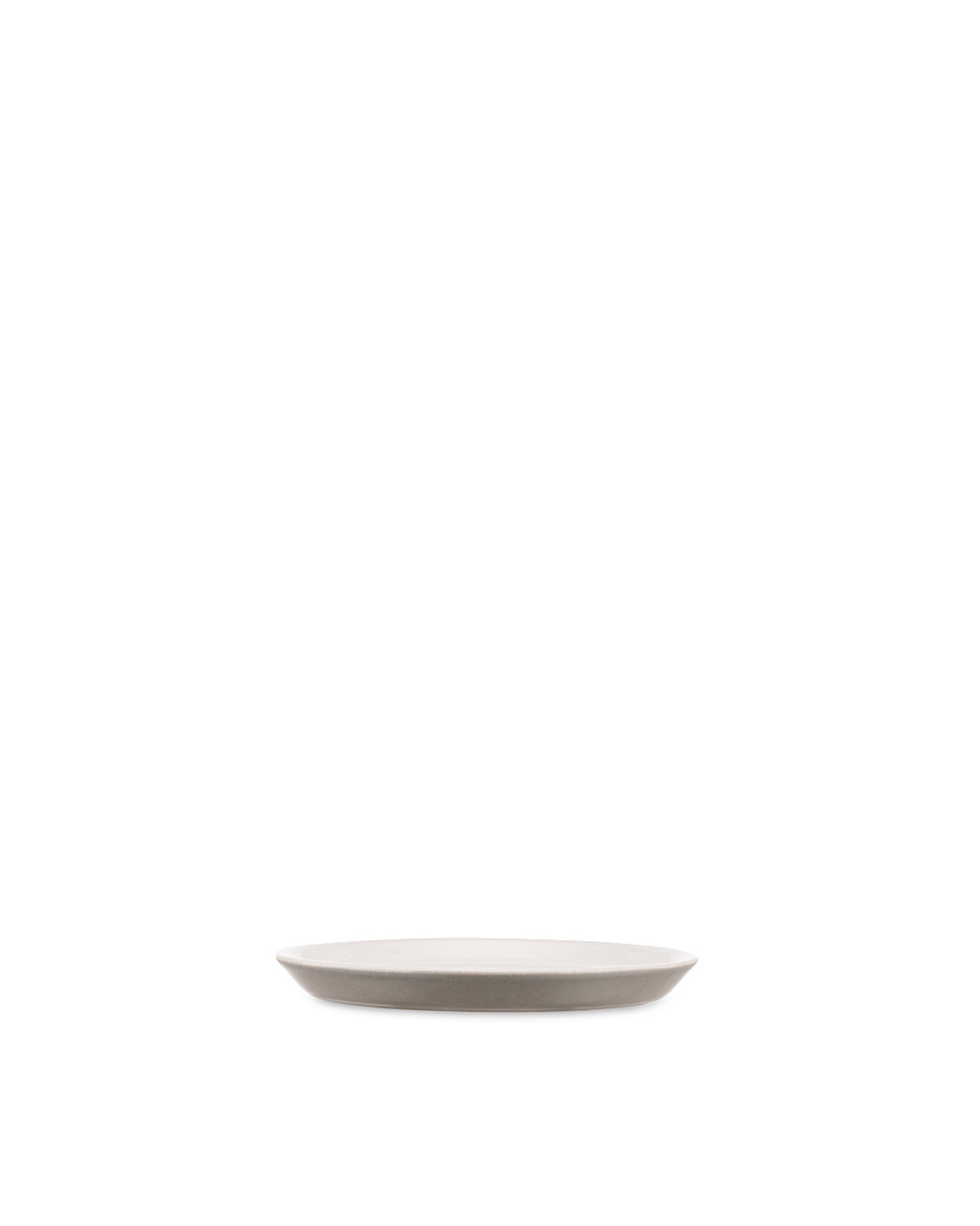 Light grey ceramic plate by Alessi with a subtle contrasting rim, side view.