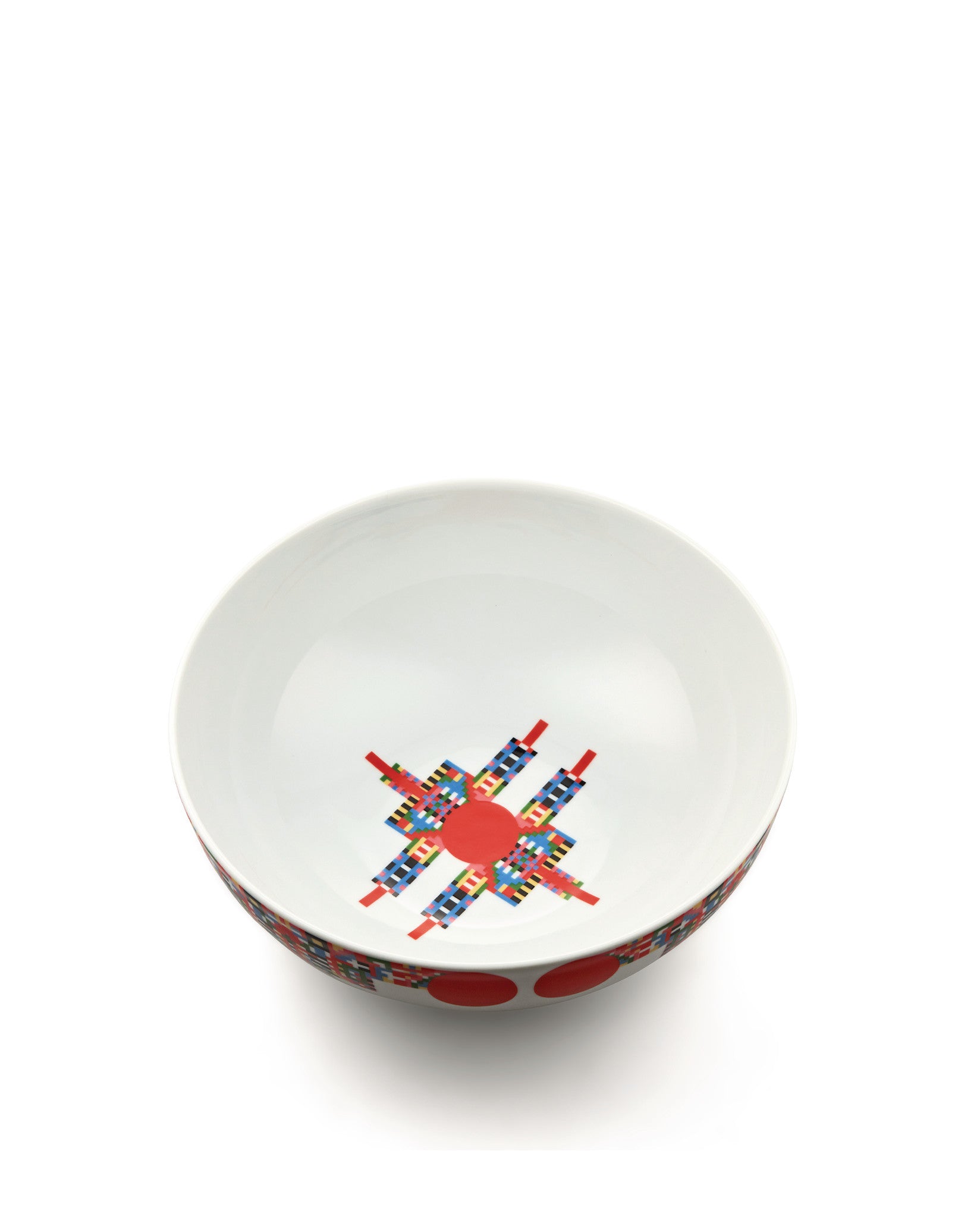 White bowl by Alessi with a pixelated, colorful star-like design inside and red dots on the outer rim.