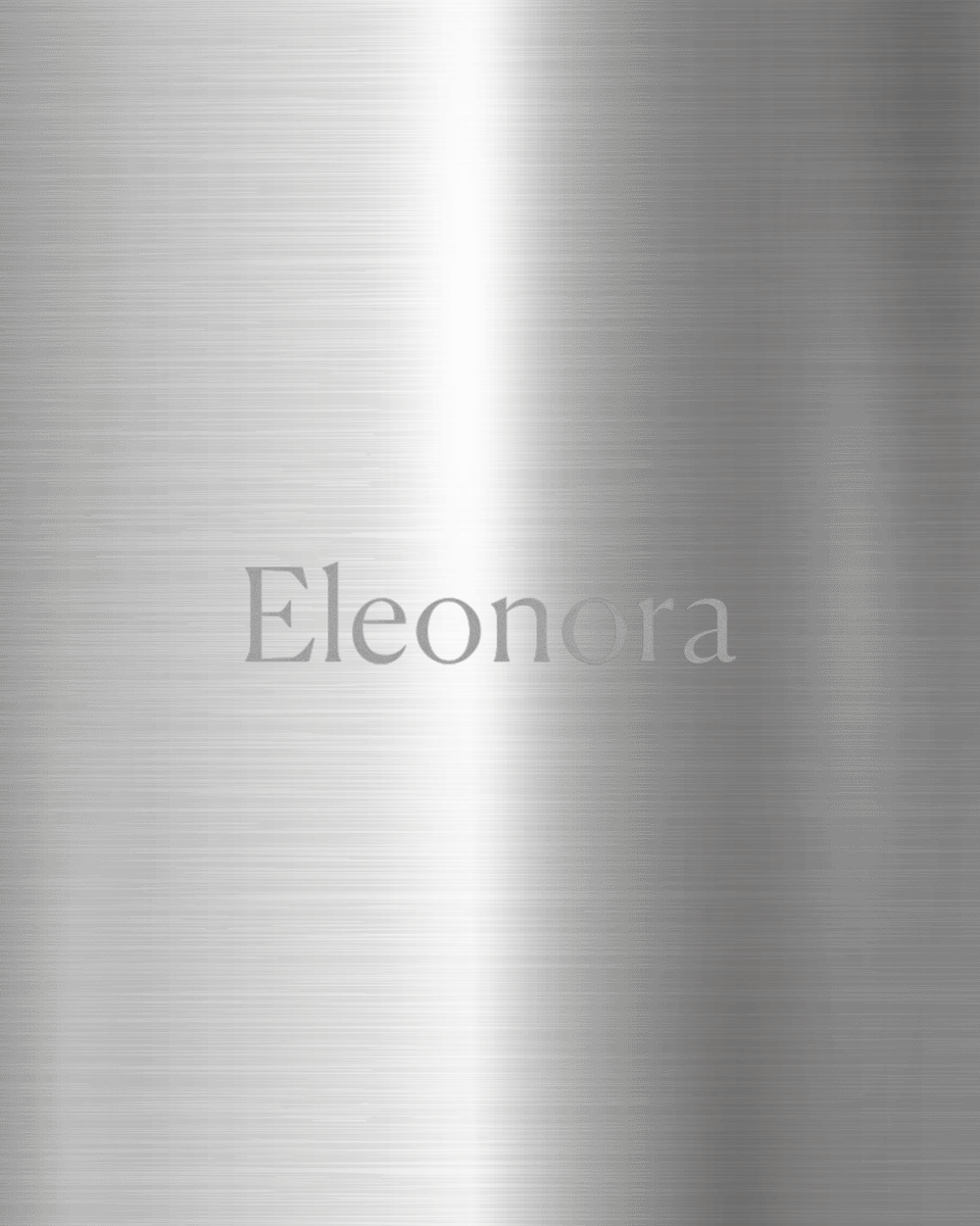 Engraved brushed metal sample by Alessi featuring the name 'Eleonora' in a silver serif font.