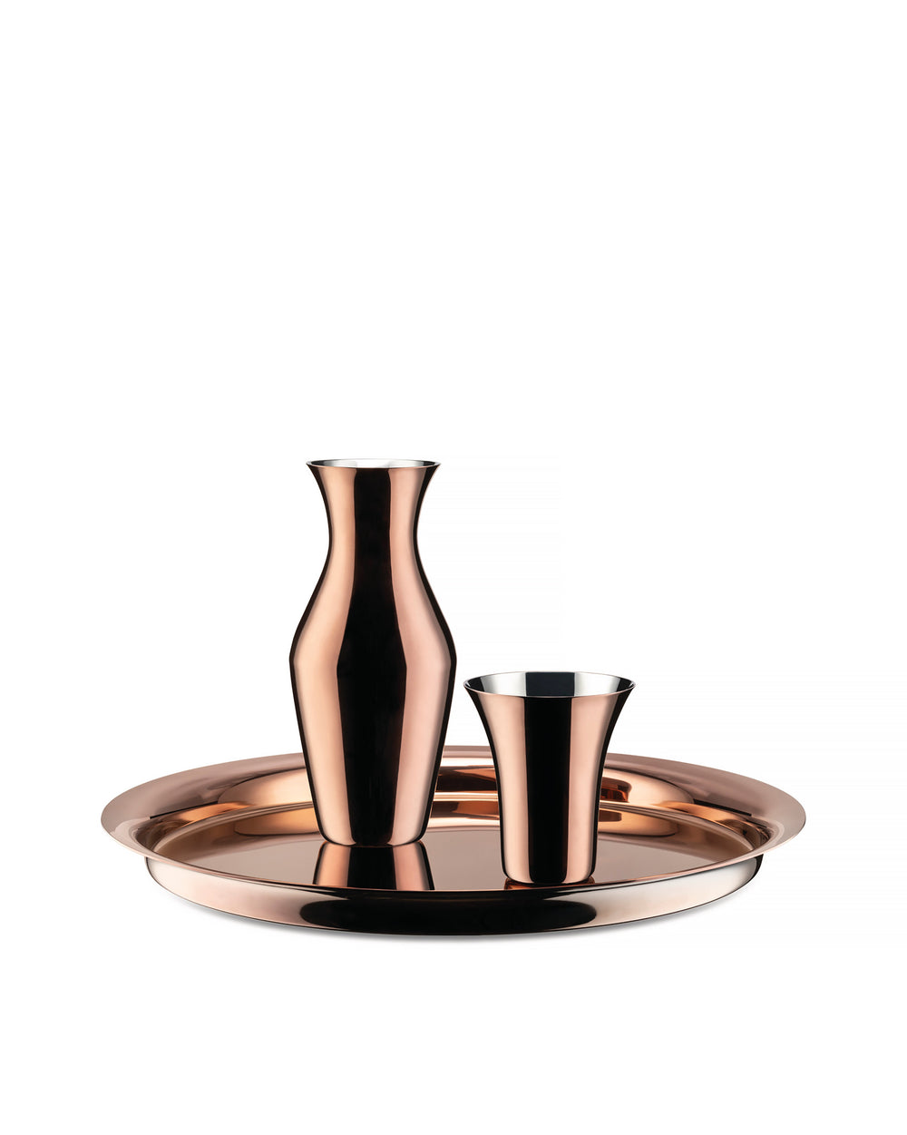 Reflective metallic copper drinking glass by Alessi, shown with a matching carafe and round serving tray.