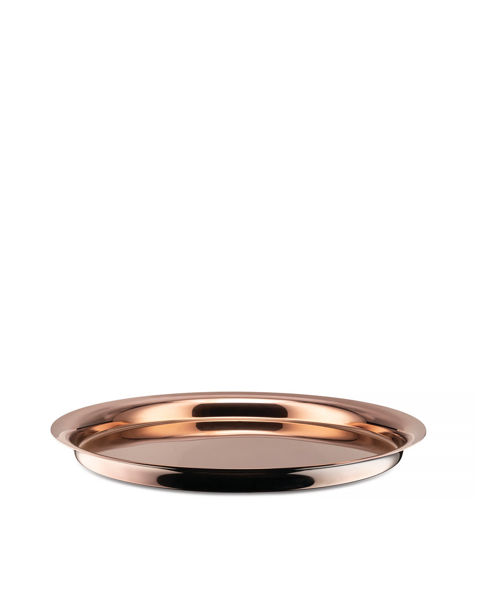 Polished copper tray by Alessi, round with a reflective surface and raised rim, seen from a low angle.