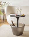 Matte black side table with smoked grey ribbed integrated ice bucket by Alessi, holding champagne and ice.