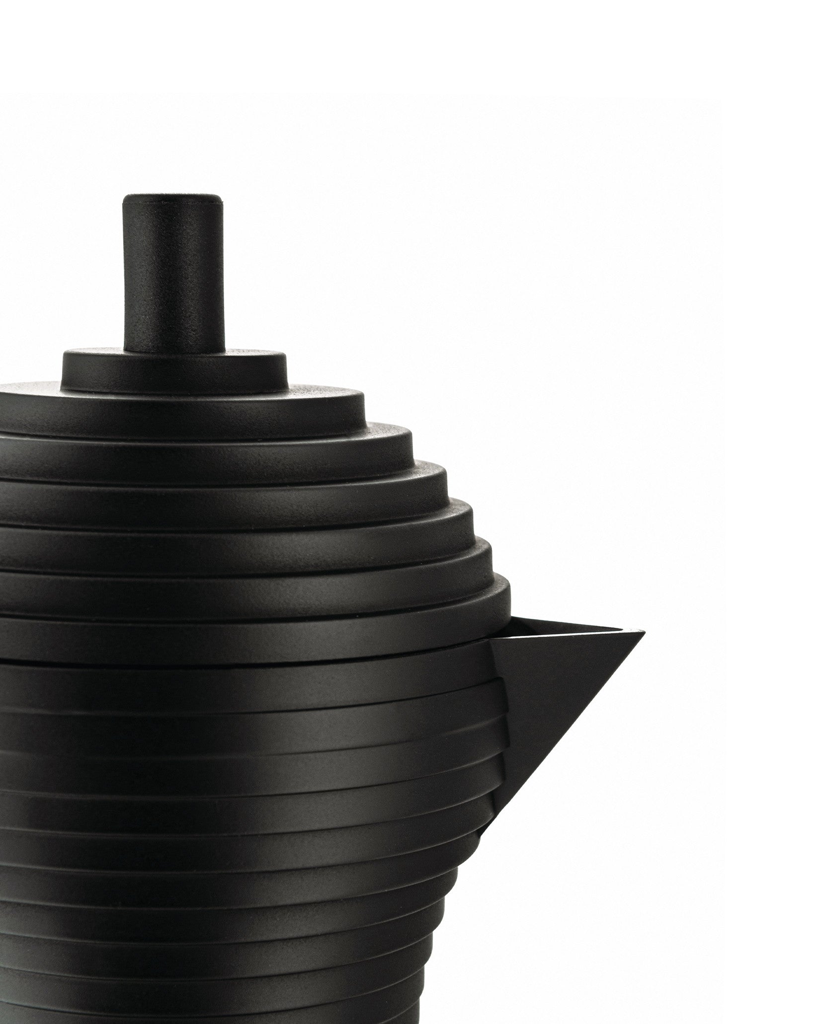 Matte black ribbed coffee maker by Alessi with a triangular spout and cylindrical top, cropped.