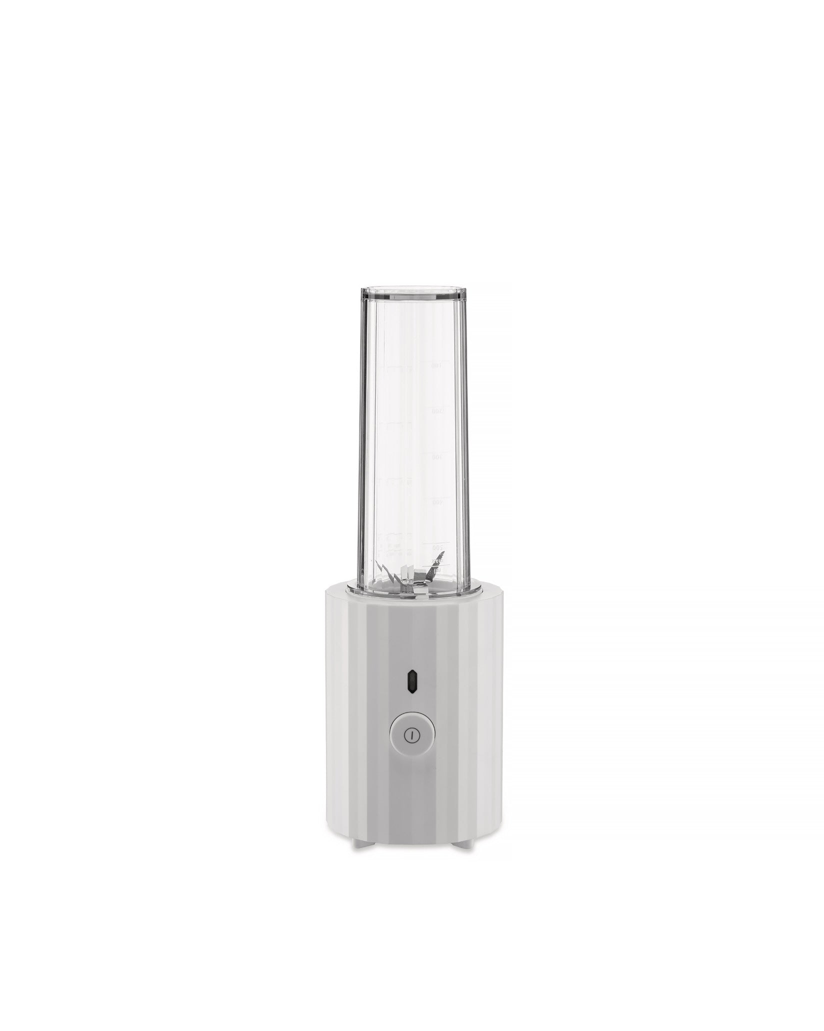 White portable blender by Alessi with a clear ribbed cup and a faceted base featuring a power button.