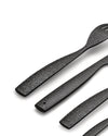 Black patterned cutlery set by Alessi with ornate embossed scroll designs on the handles.