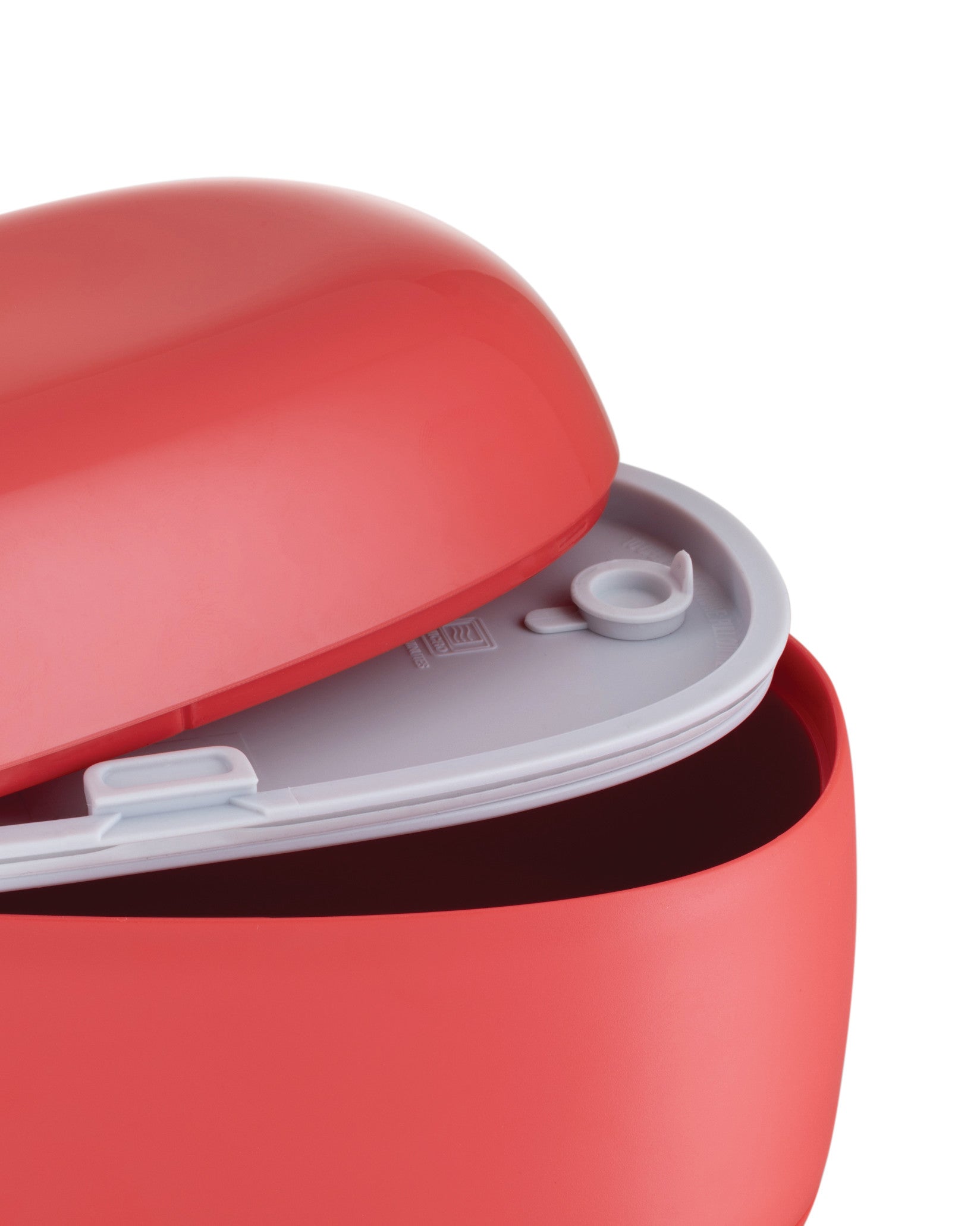 Red plastic food container by Alessi, partially open, showing a light gray interior and a small vent cap.