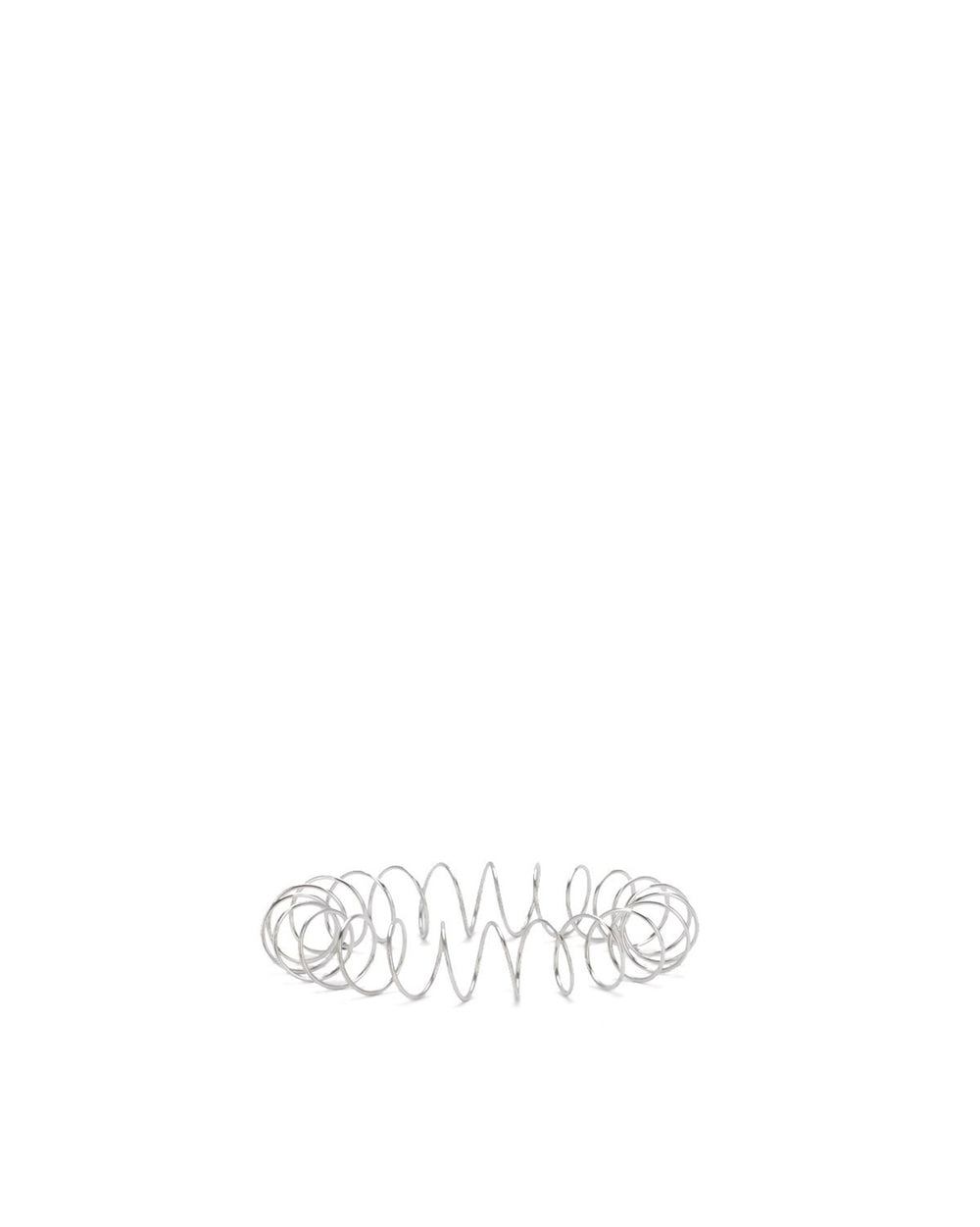 Silver metal spring by Alessi with varying coil tightness on a white background.