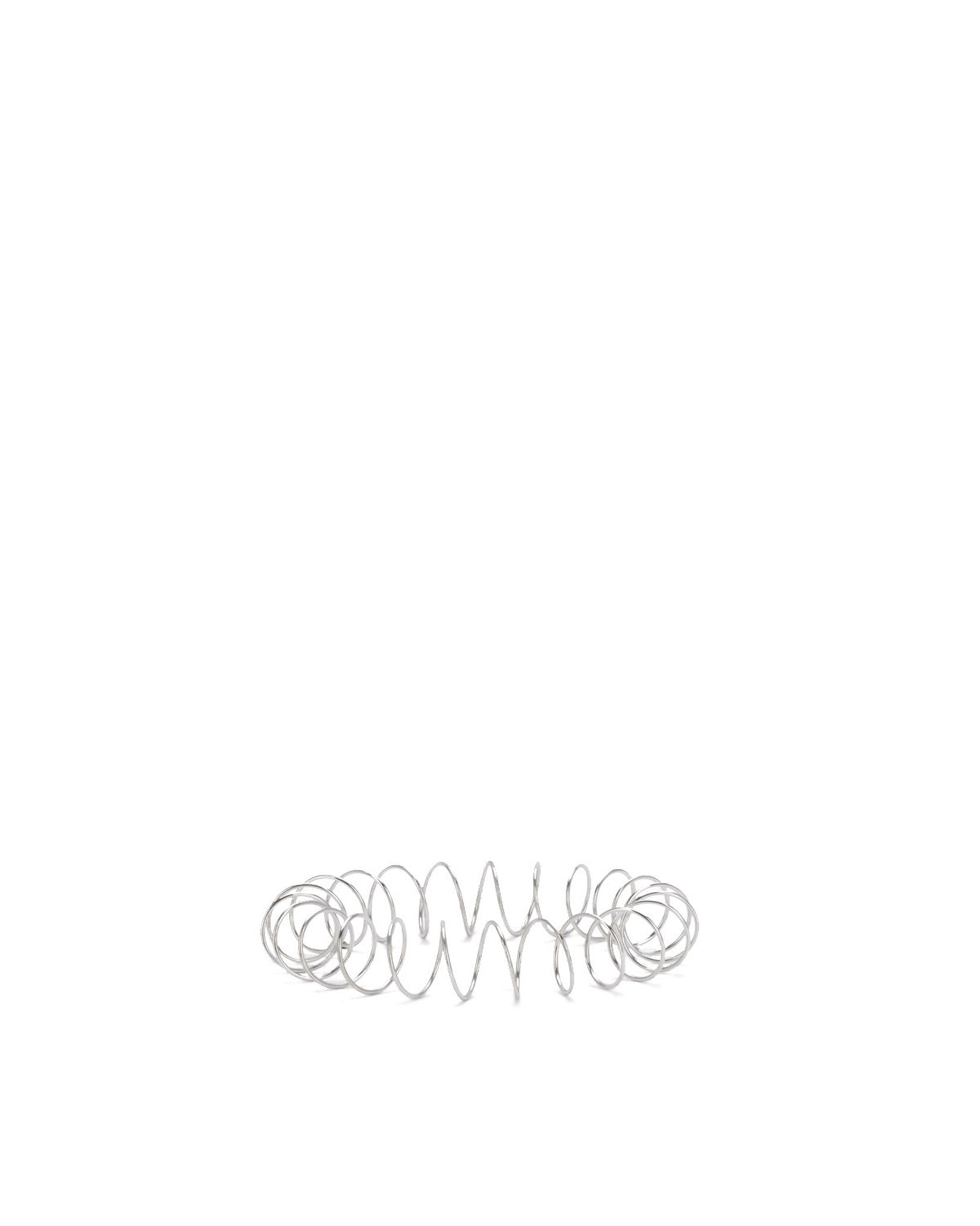 Silver metal spring spare part by Alessi, horizontally laid with loose coils in the center and tight coils at the ends.