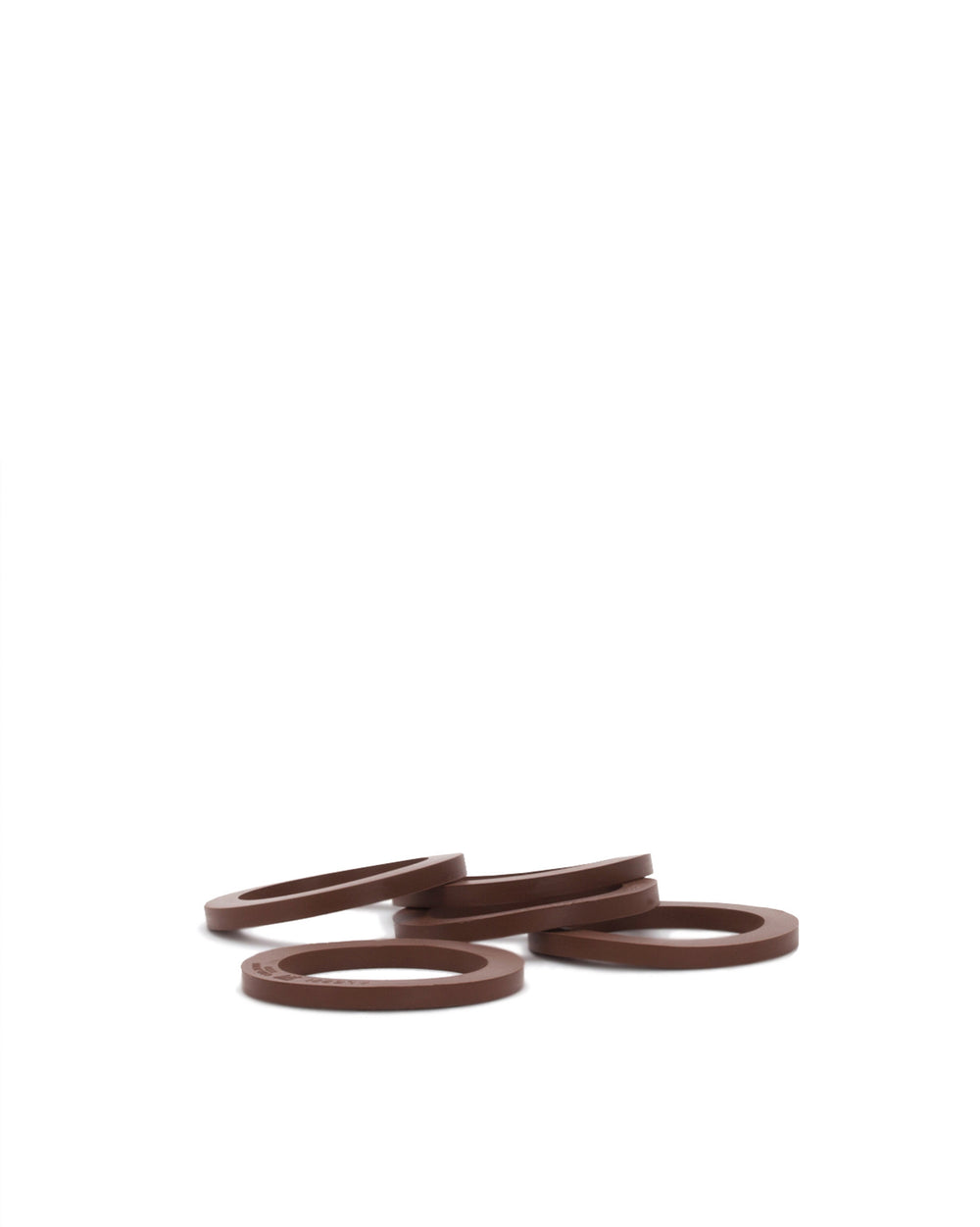 Brown flat spare part rings by Alessi, several units scattered on a white background.