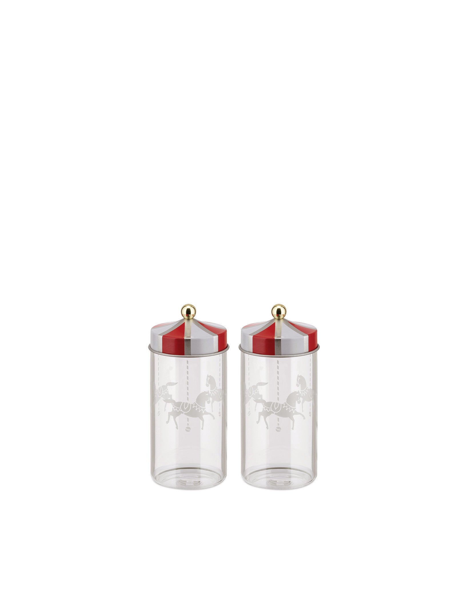Two clear glass jars with red and white striped lids by Alessi, featuring a gold knob and carousel horse etching.