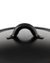 Black matte pot lid by Alessi with a curved handle and slightly textured surface, seen from a top-down view.