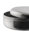 Silver round metal container by Alessi with perforated texture and slightly open lid.